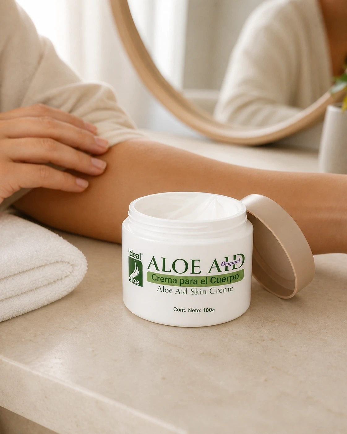 Crema corporal Aloe Aid Ideal en tarro abierto sobre un tocador junto a una modelo