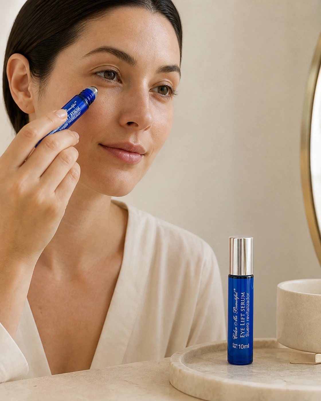 Eye Lift Serum aplicado suavemente en el contorno de ojos junto a un tocador minimalista