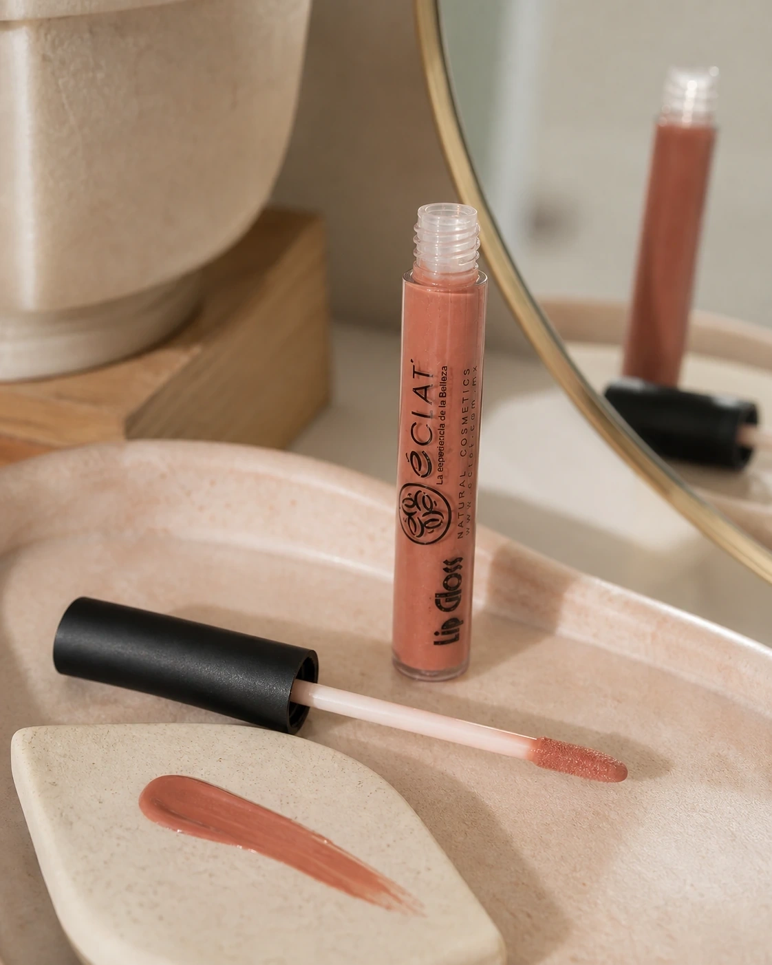 Lip gloss Eclat nude durazno abierto con aplicador y muestra sobre tocador