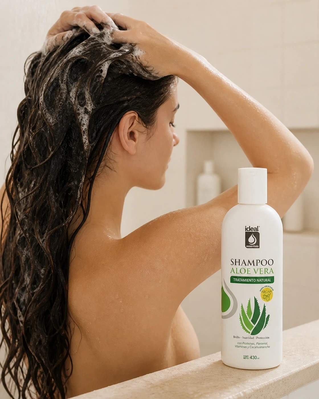 Persona lavando el cabello húmedo con Shampoo Aloe Vera, con la botella visible.