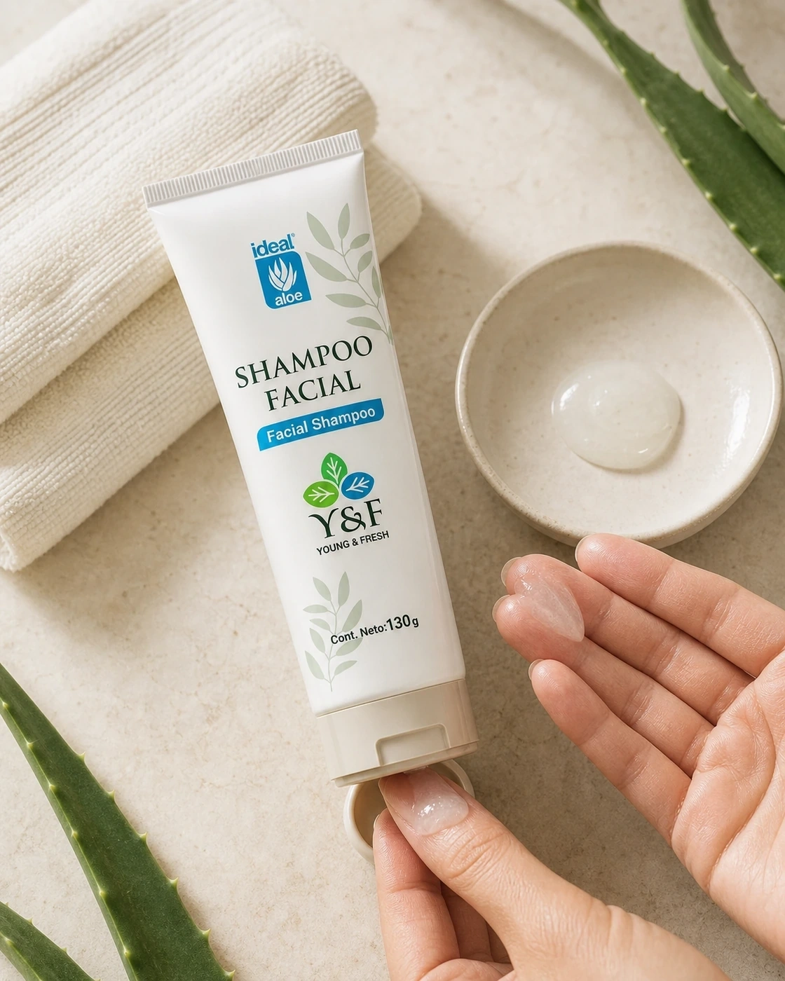 Shampoo Facial Young & Fresh aplicado sobre las manos junto a un cuenco de limpiador